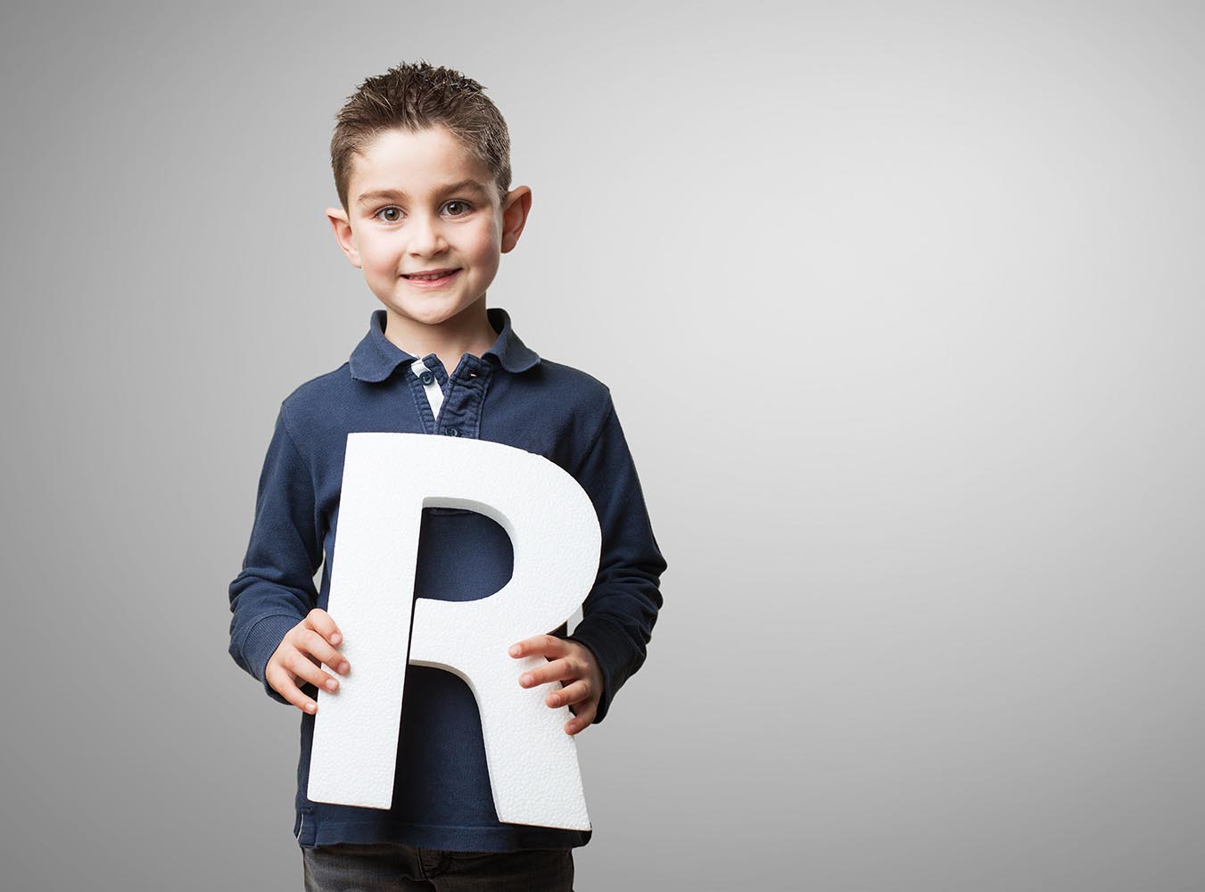 Child Holding Letter R in Hand